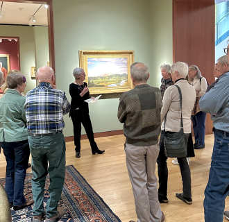 group of visitors in a Museum gallery looking at a landscape painting
