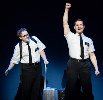 Two white men wearing missionary outfit looking excited.