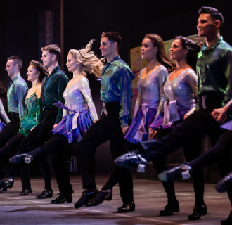 Line of Irish step dancers on stage.