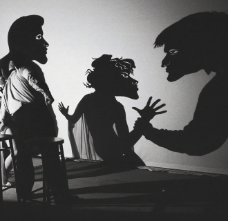 Actors performing shadow puppetry