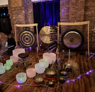 Gongs, colorful singing bowls, and lights setup for sound meditation