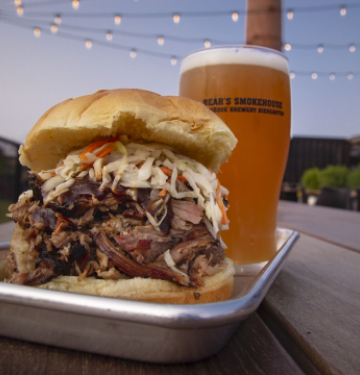 Barbecue pulled pork sandwich with coleslaw and beer at outdoor patio