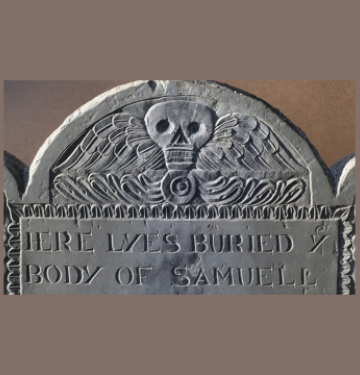 Old gravestone with winged skull carving and partial epitaph