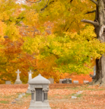 Autumn cemetery with tombstones and colorful fall foliage