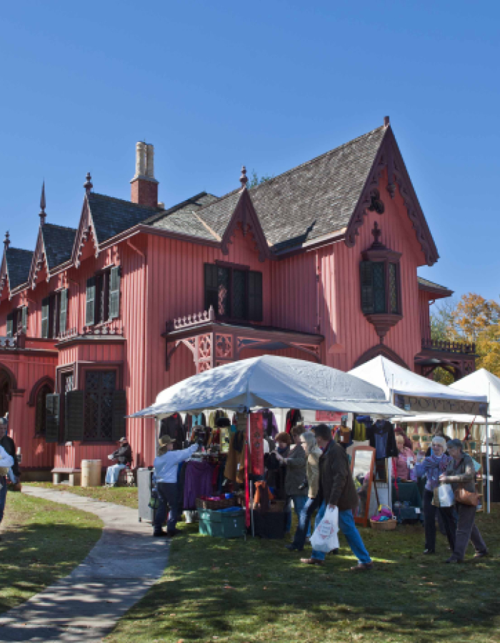 Roseland Cottage with market tents and people at outdoor fair