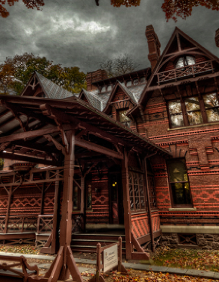Victorian brick house under cloudy sky in autumn with wooden porch