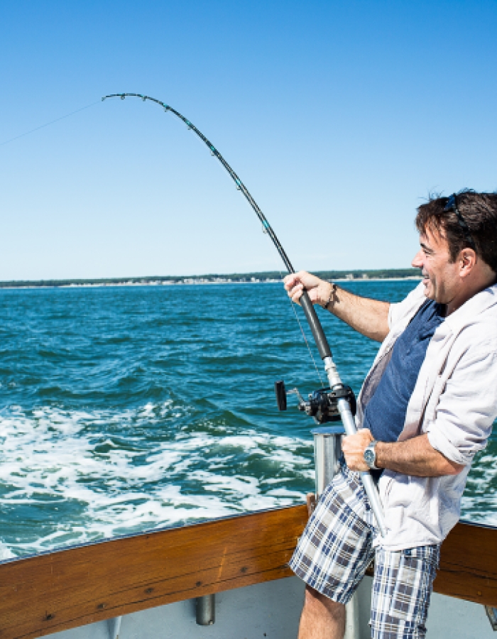 Cropped Image Of Man Holding Fishing Rod Against Clear Sky Art