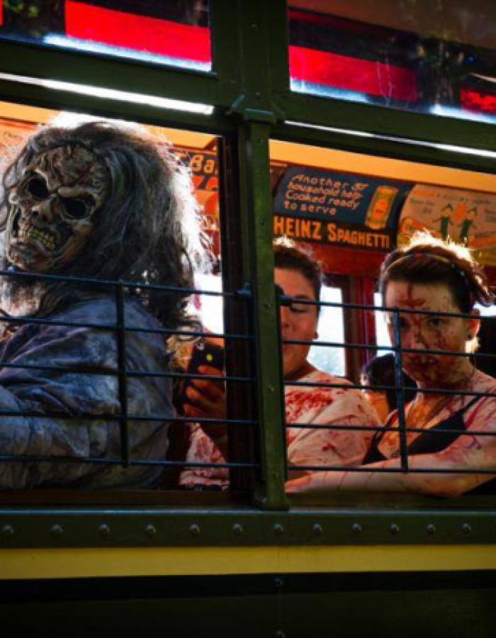 People in gruesome zombie costumes sitting inside a trolley car