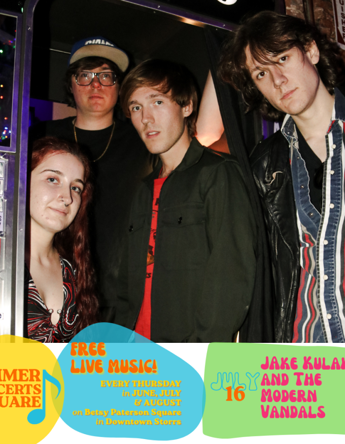 Four young people gather in and around a photo booth