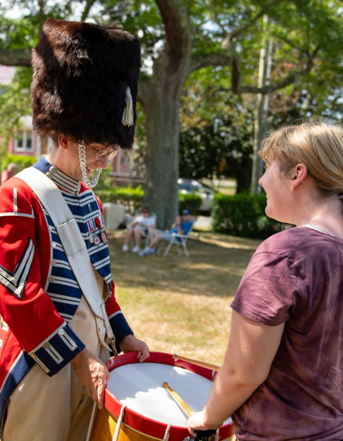 A revolutionary war reenactor and a museum visitor. 