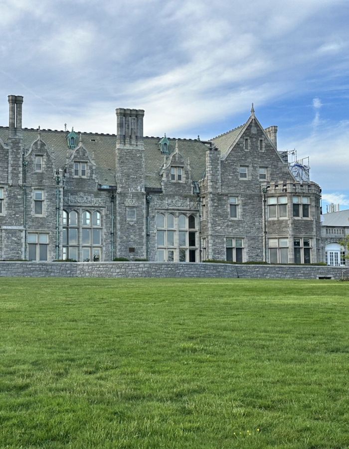Branford House, a historic stone mansion overlooking a green lawn, featured on Thames River Heritage Park's Gilded Age tour.