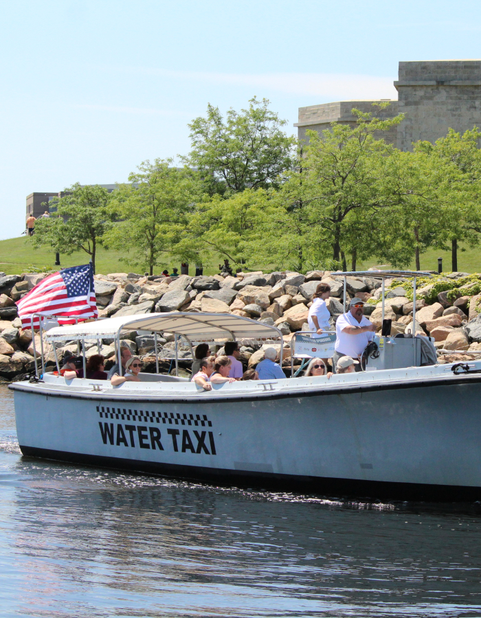 Hop On, Hop Off Harbor Cruise in the river with Fort Trumbull in the background.