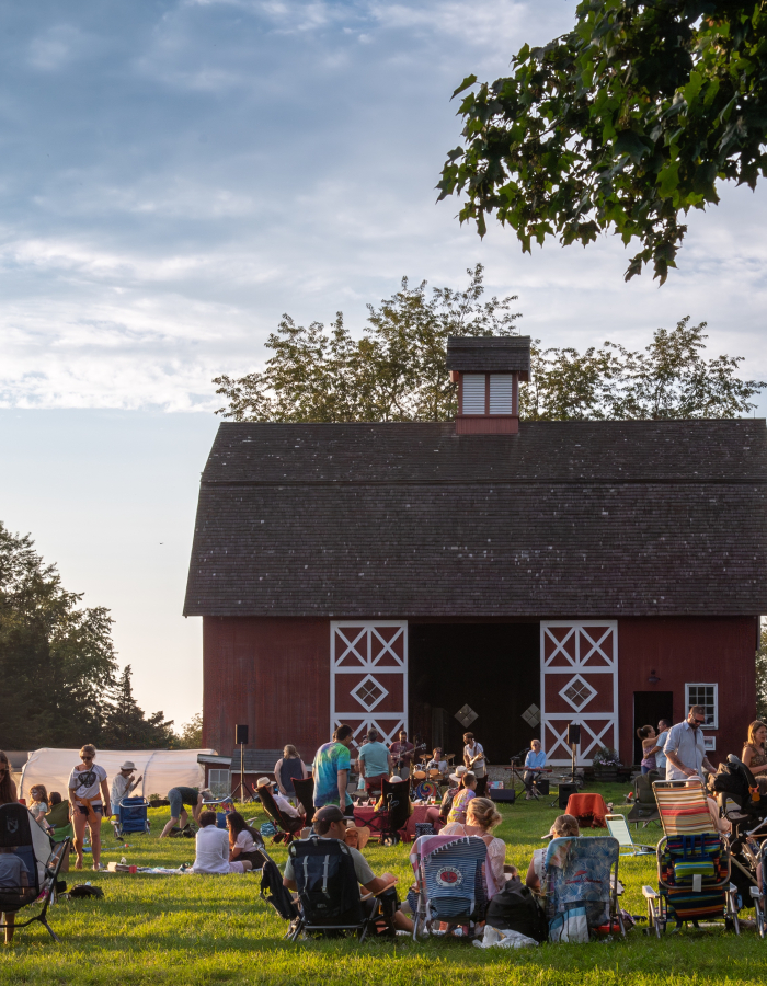 Crowd enjoys music and food in front of Red Barn