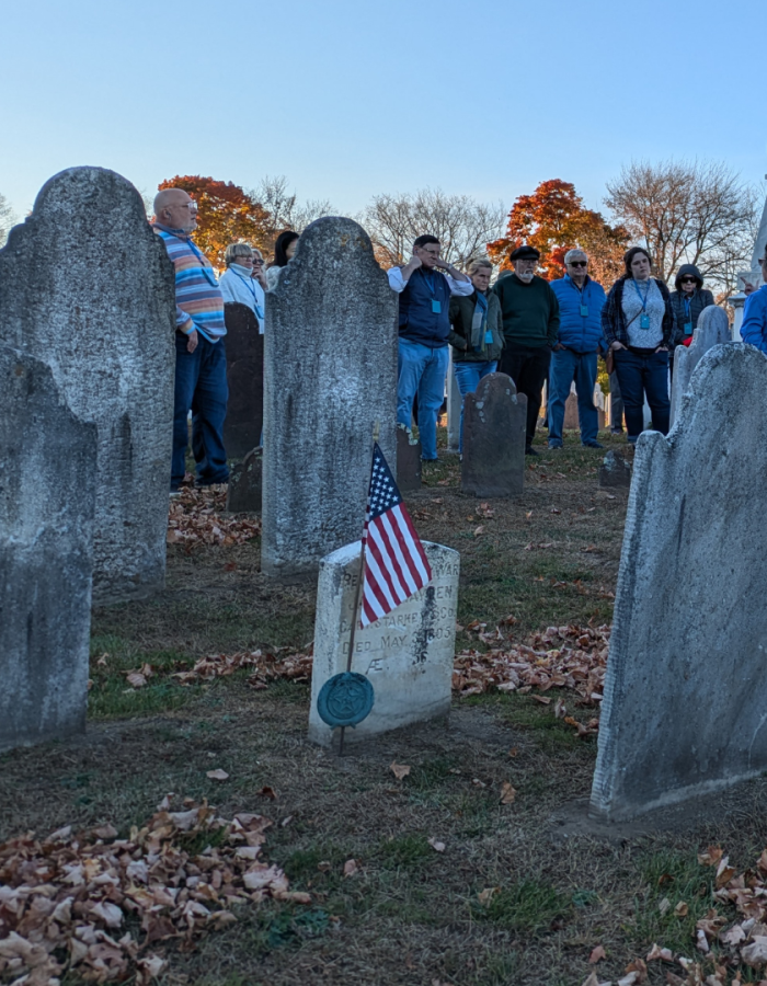 Gravestones at River View Cemetery with tour group in the background