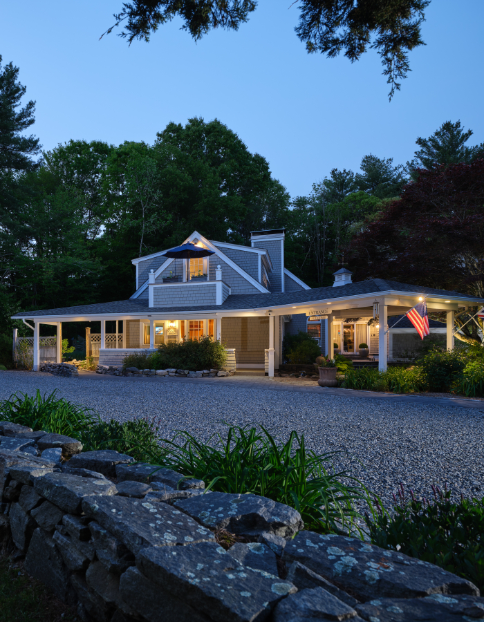 The main house and cottage at Abbey's Lantern Hill Inn illuminated at dusk