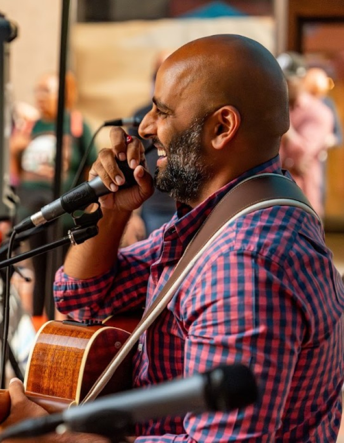 Mayor Arunan playing the guitar in front of an audience.