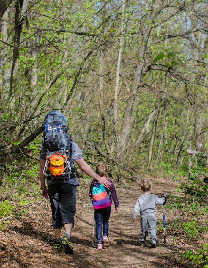 A family goes out for a hike on a sunny day.