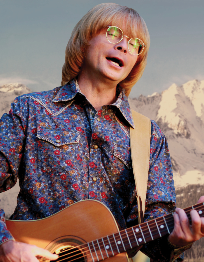 Man in floral shirt playing guitar with Rocky Mountain background 