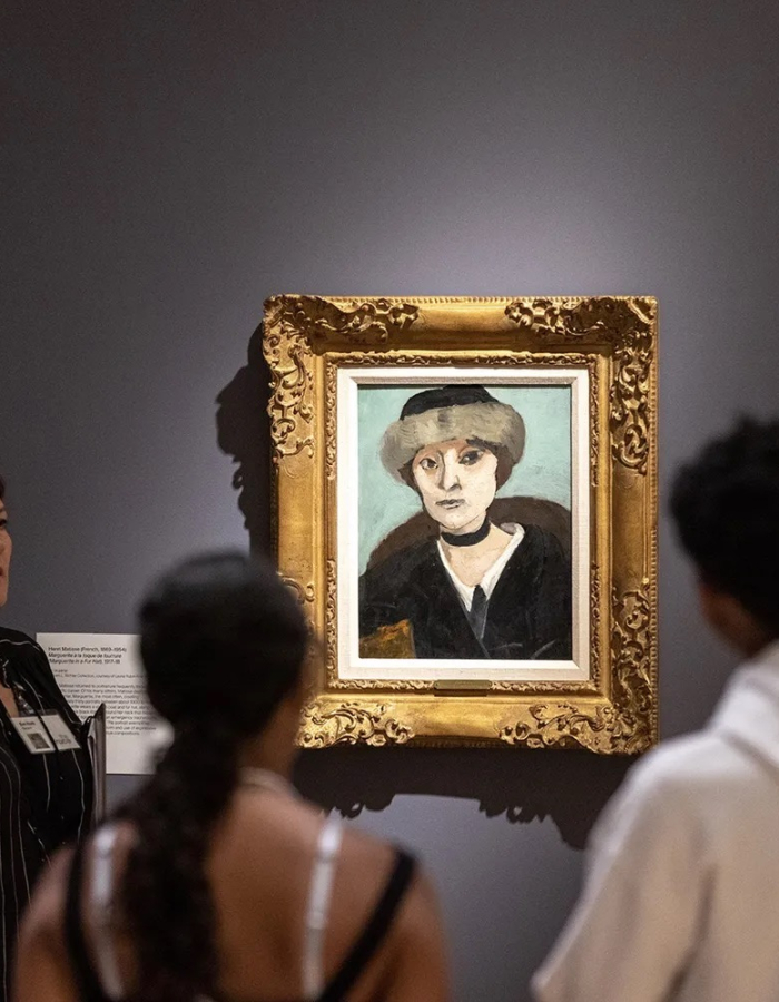 People in a museum looking at a portrait 