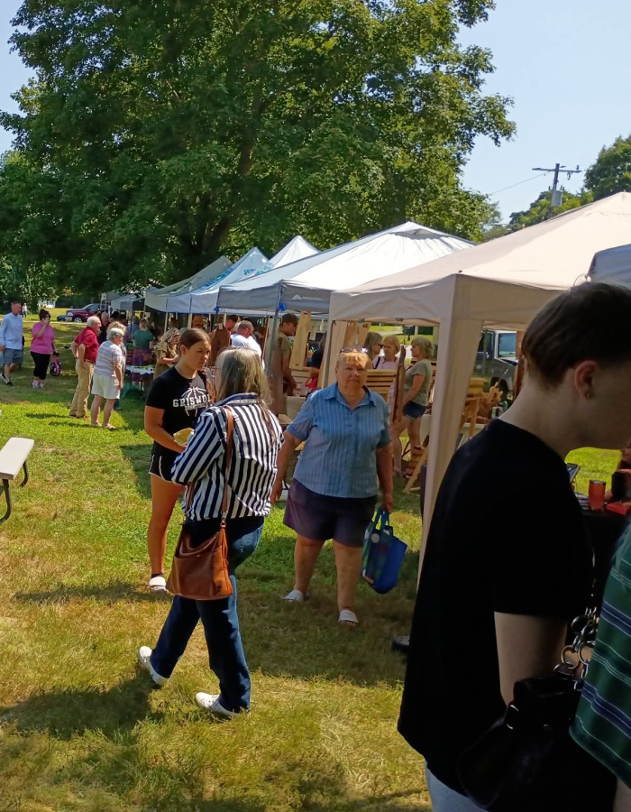 Vendor tents and market guests at the Voluntown Farmers Market. 