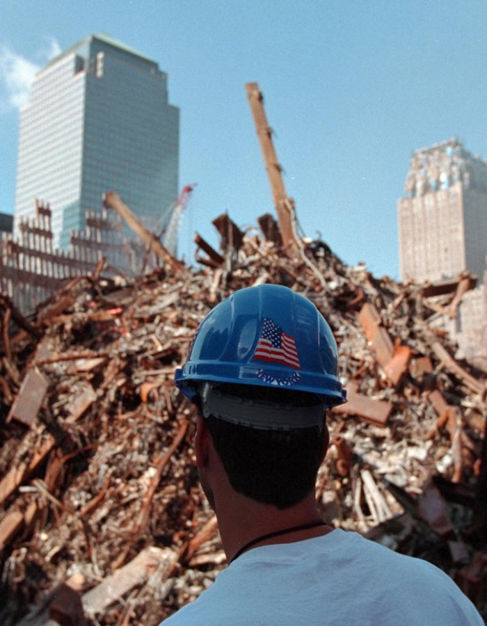 A new york first responder looking at the extent of the damage before him, which includes rebar and rubble. 