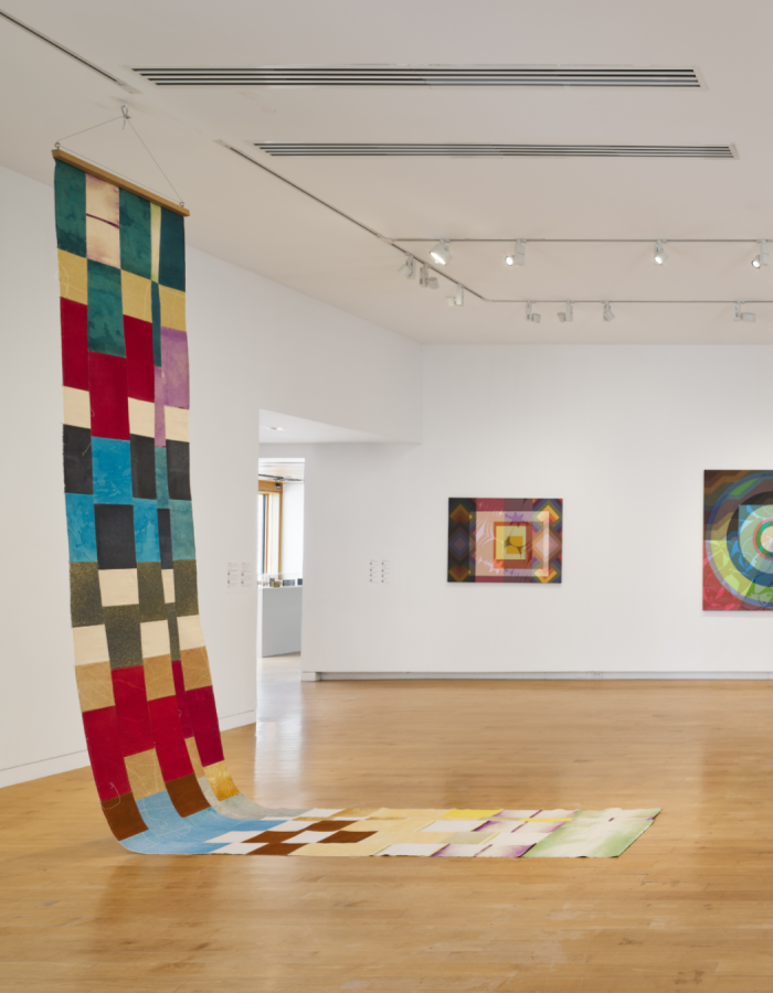 A view of a gallery with colorful painting and sculpture