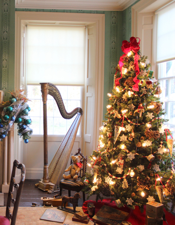 The historic parlor at the Florence Griswold Museum decorated for the holidays: a lit Christmas tree and decorated mantel