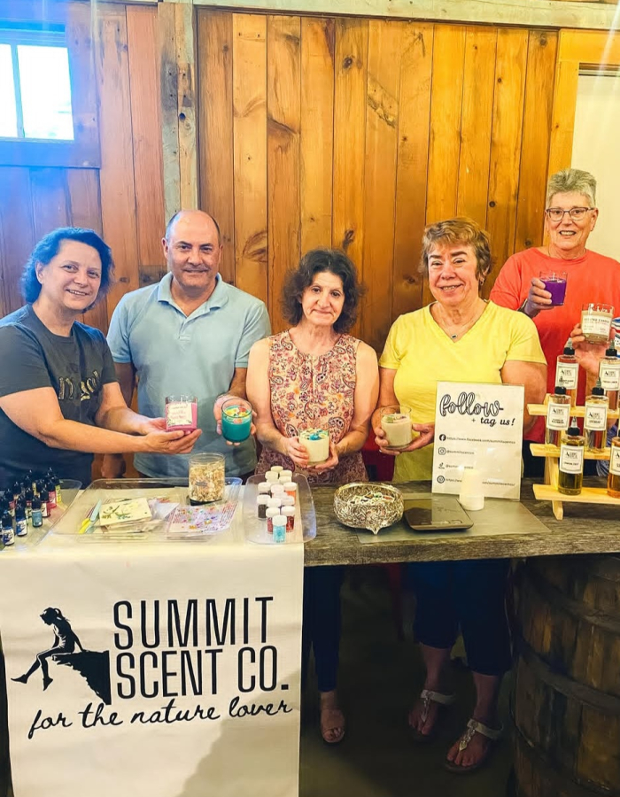 A group of people showing off the candles they made
