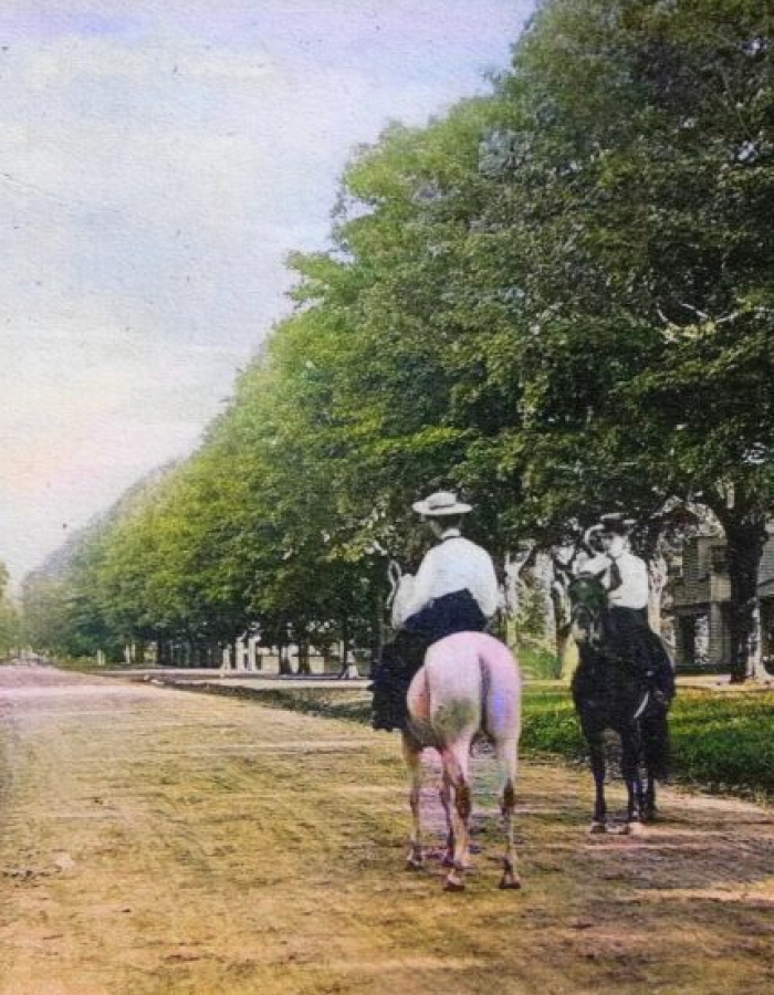 two people on horses going down old main street