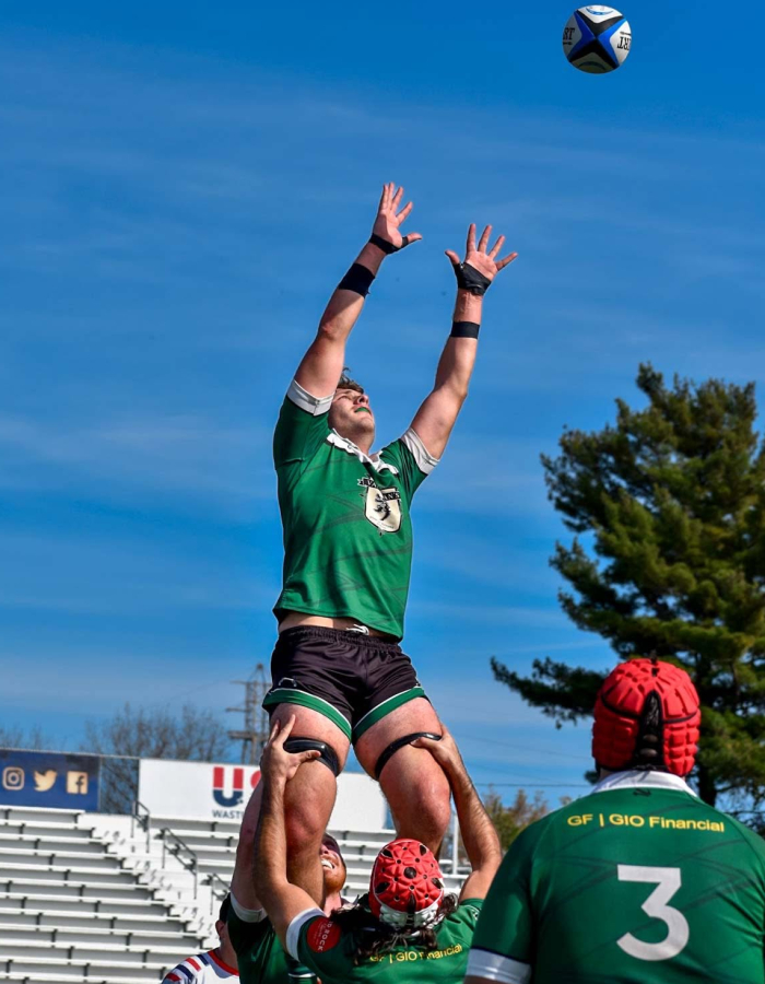 A rugby player leaps for the ball during a game