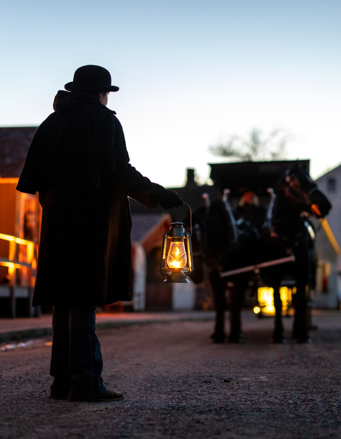 Horse drawn carriage led by lantern light