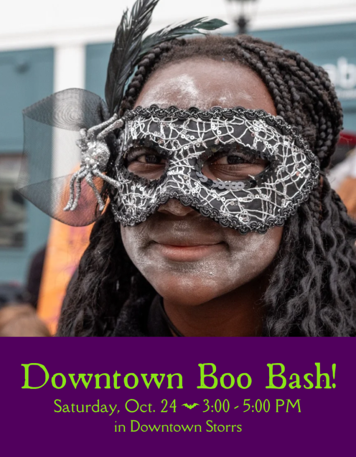 A teen wears a Halloween mask adorned with a glittering spider and black feathers