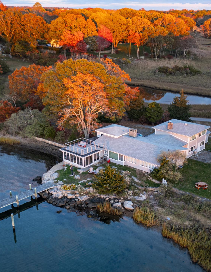 Aerial view of 26 Schoolhouse at the edge of the Mystic River, amid autumn marsh and trees