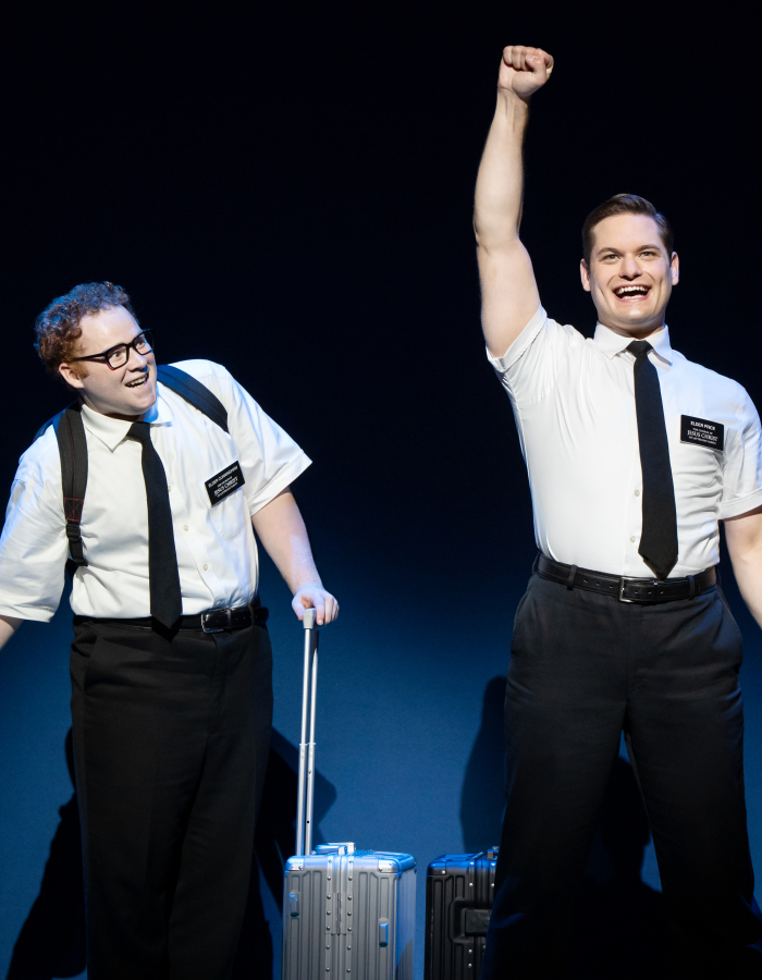 Two white men wearing missionary outfit looking excited.