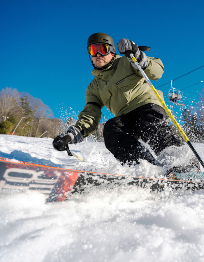 Skier carving on trail and creating snow spray