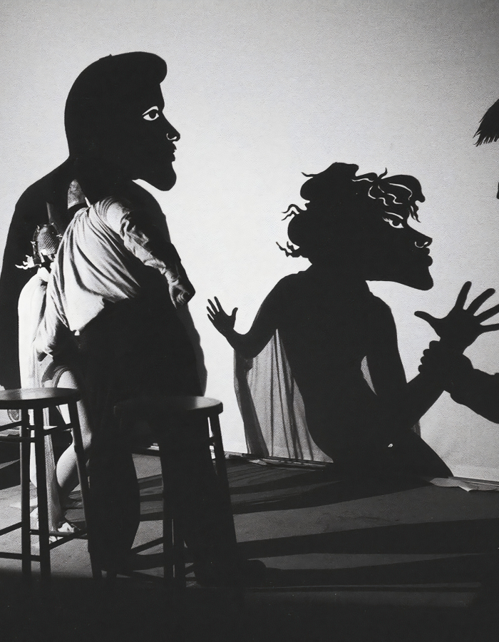 Actors performing shadow puppetry