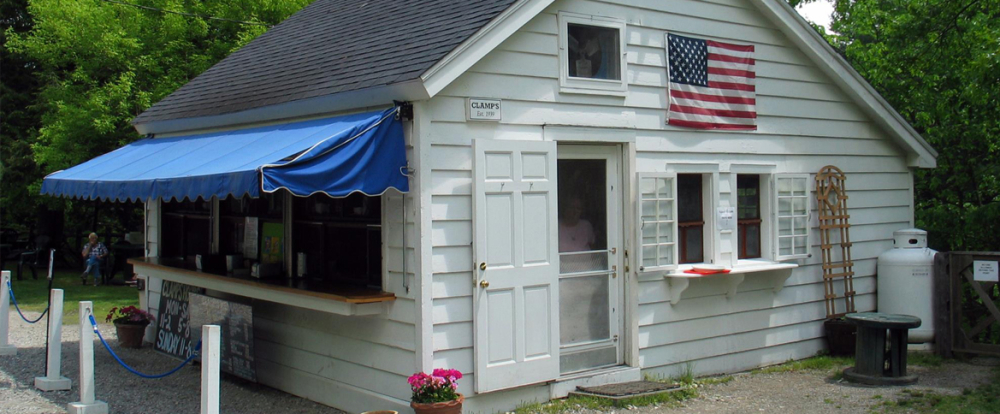 Small white food stand with blue awning and American flag