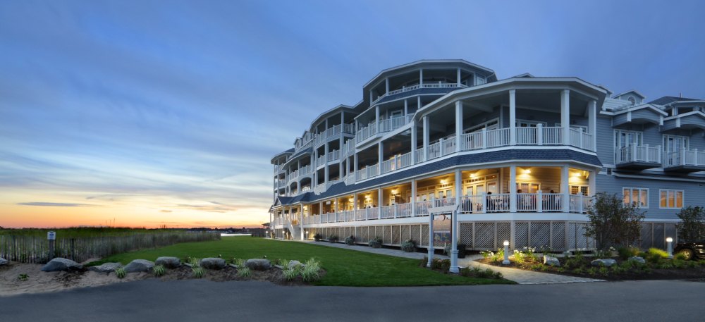Large multi-story beachside hotel at sunset with lit balconies