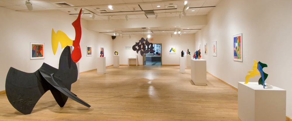 Modern colorful abstract sculptures and paintings in white-walled art gallery