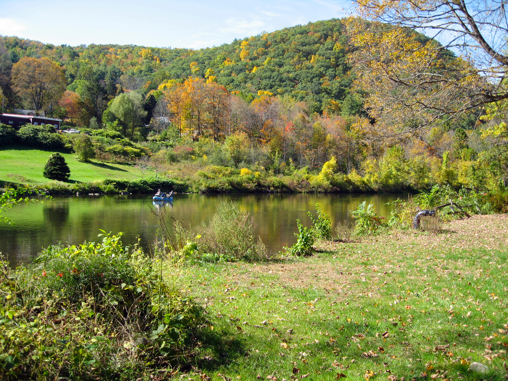 Housatonic River with fall foliage and two people in a small boat