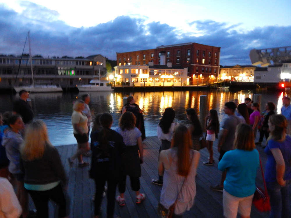 Group gathered on dock by water at twilight in Mystic River Park
