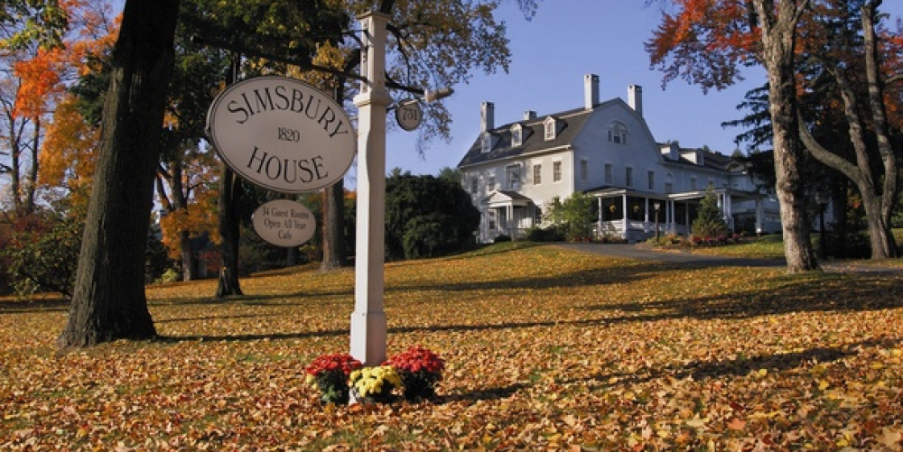 Simsbury House with fall foliage and leaves covering the ground