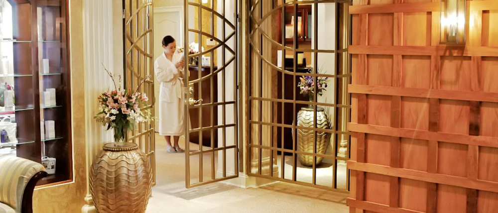 Woman in bathrobe entering elegant spa reception area