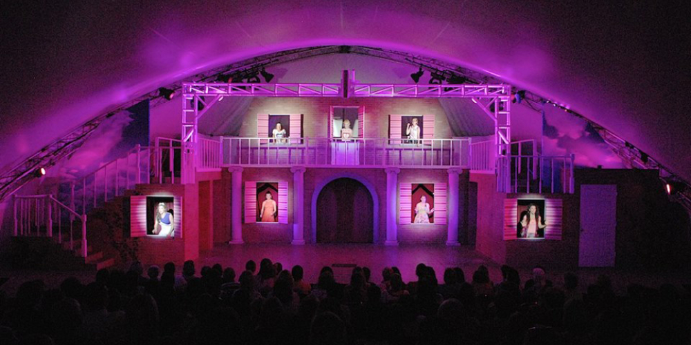 Actors performing on a lit stage at Summer Theatre of New Canaan
