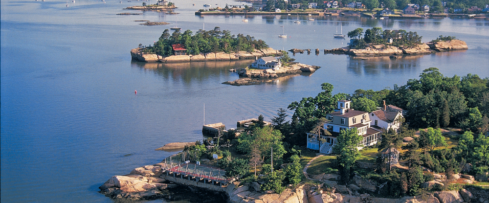 Small rocky islands with houses and trees in a calm coastal bay