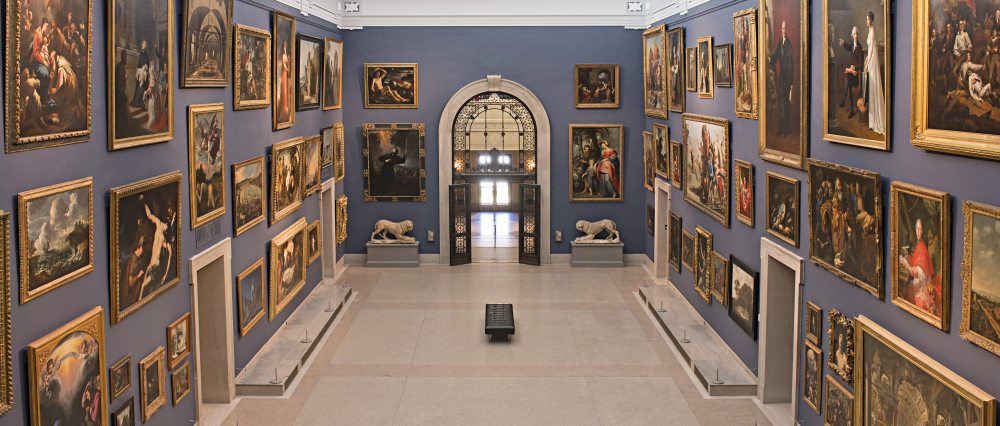 Great Hall with blue walls displaying classical paintings in gold frames