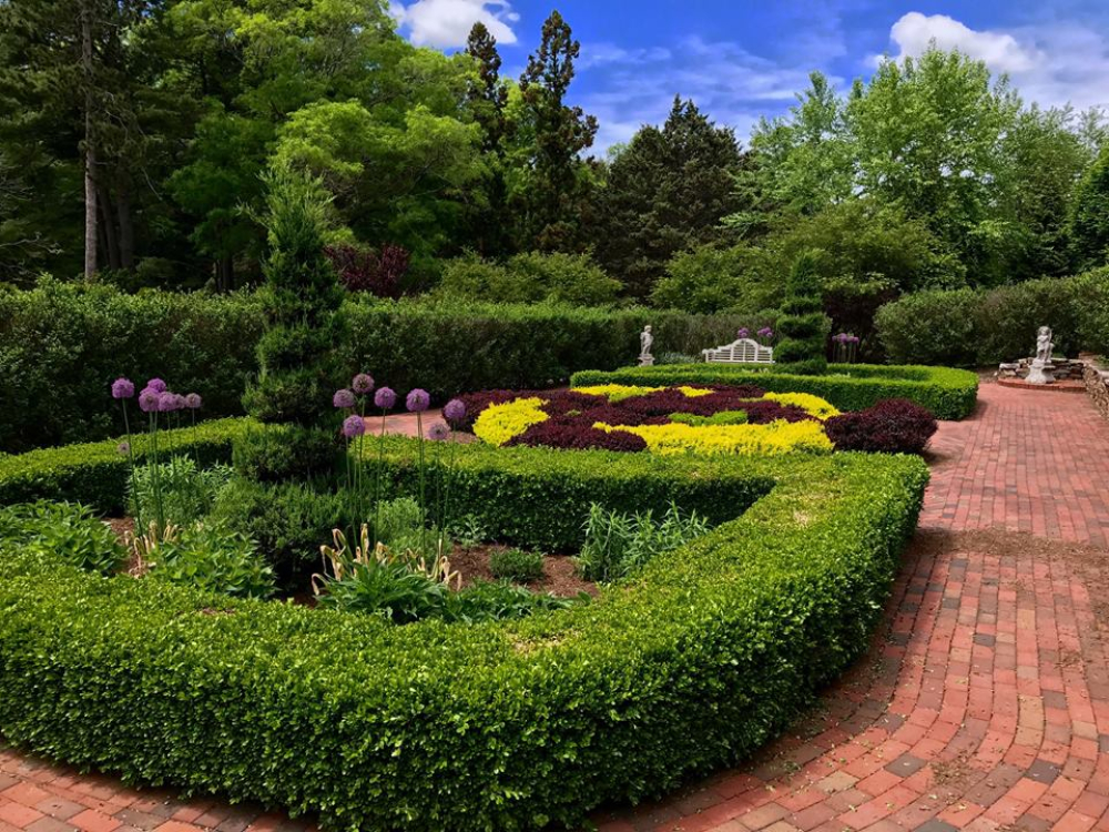 Manicured garden beds with colorful flowers and brick pathways at Wickham Park