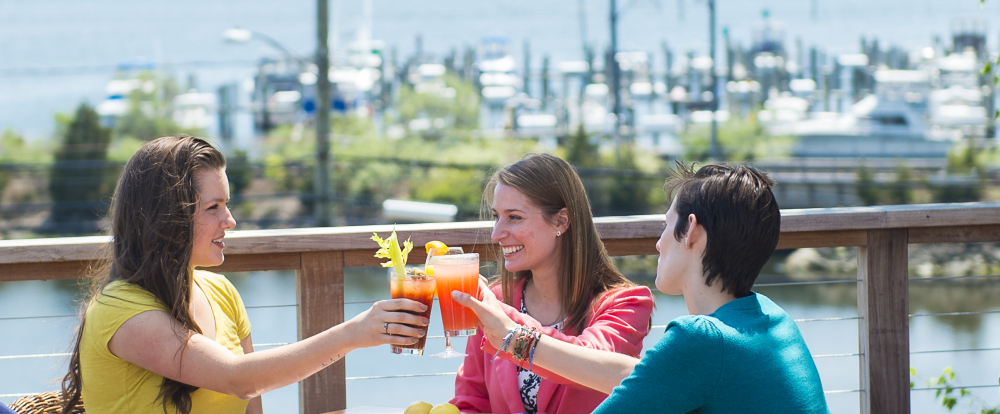 People enjoying drinks at outdoor waterfront restaurant patio