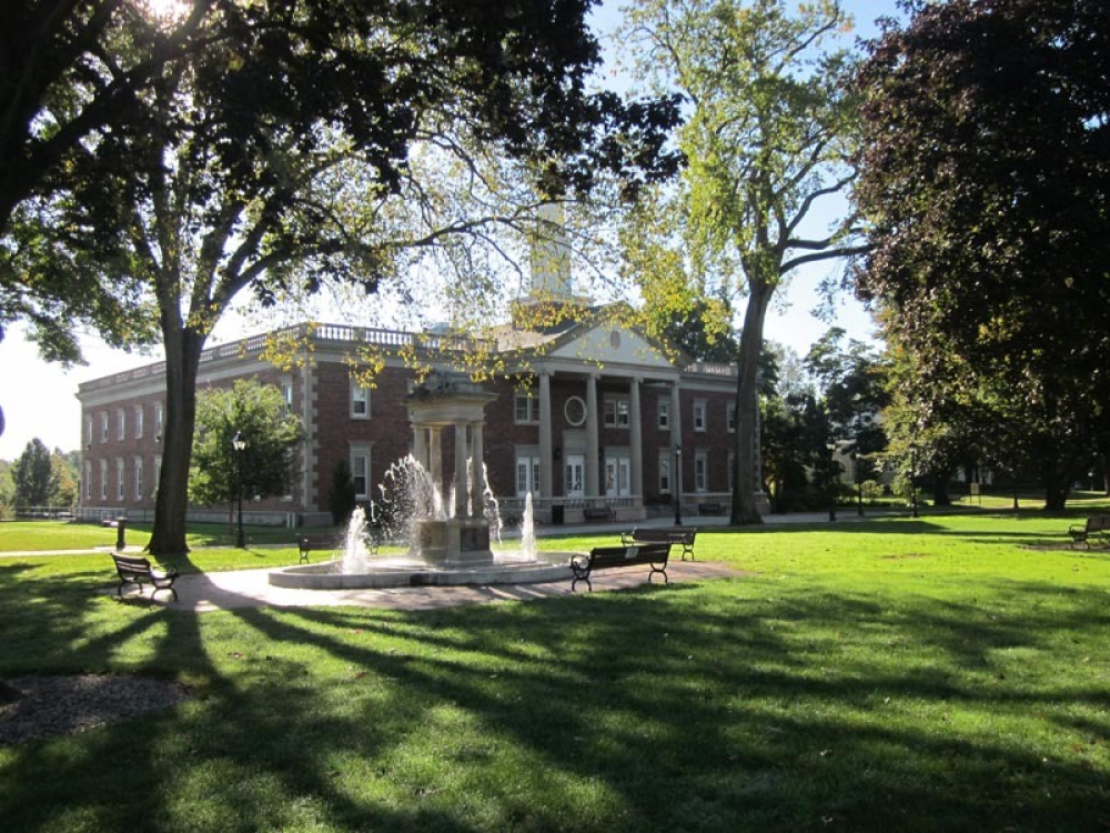 Windsor town green with fountain, benches, large trees, and brick building