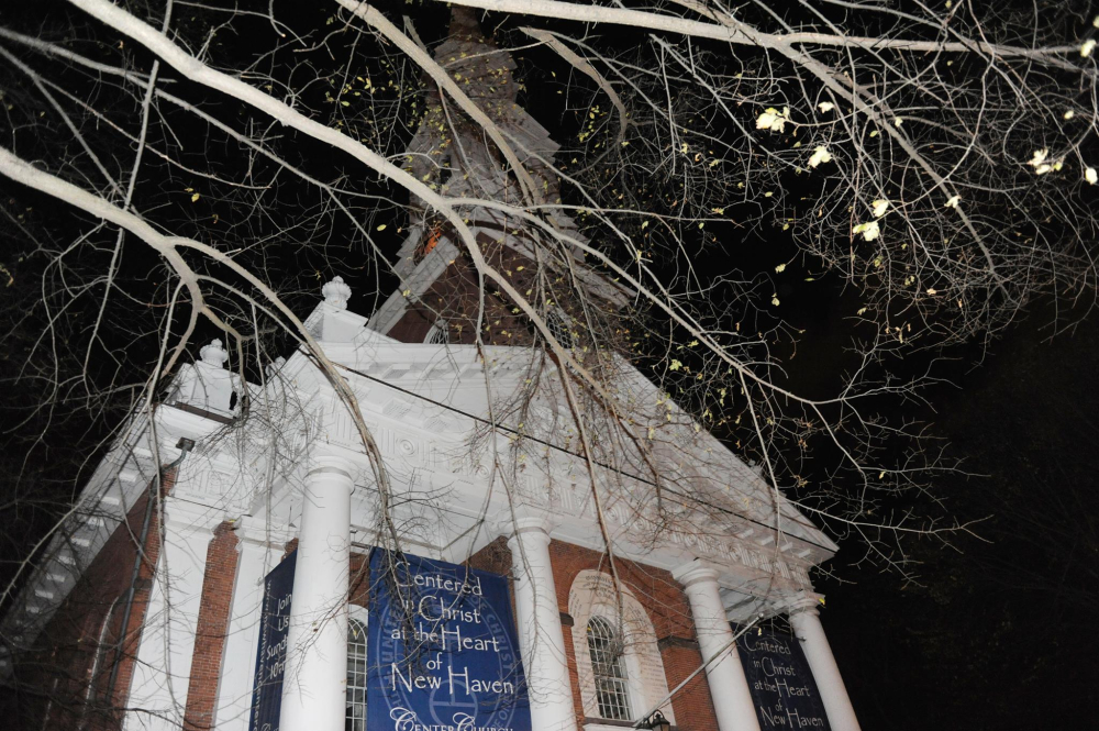 Night view of New Haven church steeple with leafless tree branches